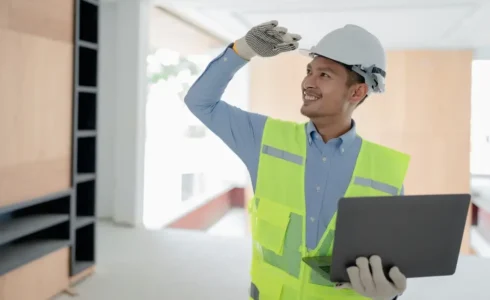 Worker holding OSHA card while wearing PPE on construction site