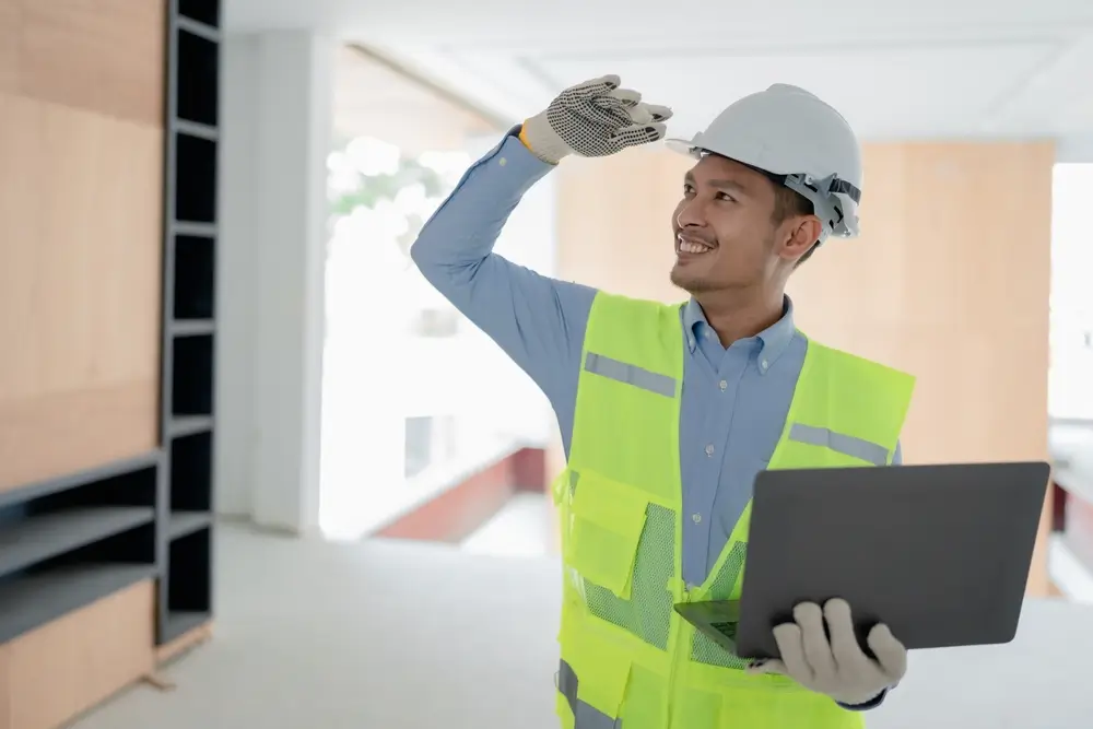 Worker holding OSHA card while wearing PPE on construction site